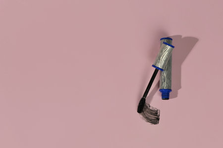 Black mascara in silver tube with sample on pink backgroundの写真素材
