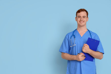 Male medical student with clipboard on blue backgroundの写真素材