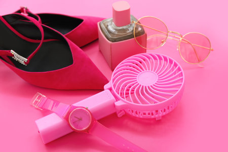 Composition with portable electric fan and stylish female accessories on pink background, closeupの写真素材