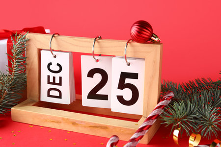 Decorations and calendar with date of Christmas on red backgroundの写真素材