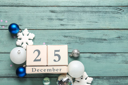 Decorations and calendar with date of Christmas on blue wooden background