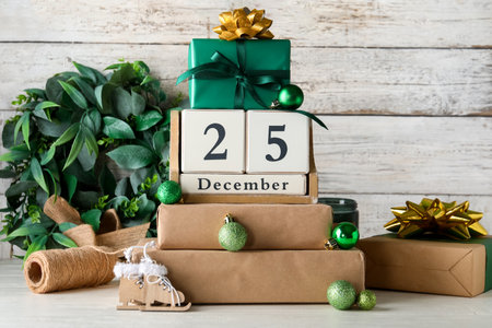 Decorations, gift boxes and calendar with date of Christmas on wooden backgroundの写真素材