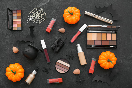 Composition with different makeup products and Halloween decor on black backgroundの写真素材