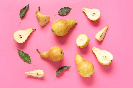Ripe pears and leaves on pink background
