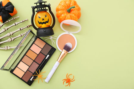 Makeup products and Halloween decor on green backgroundの写真素材