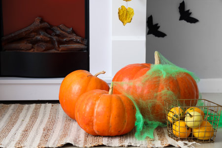 Halloween pumpkins with web on rug in living roomの写真素材