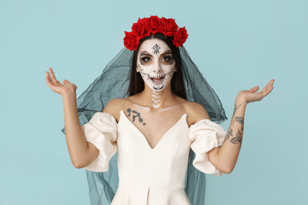 Beautiful shocked young woman dressed as dead bride for Halloween party on blue background