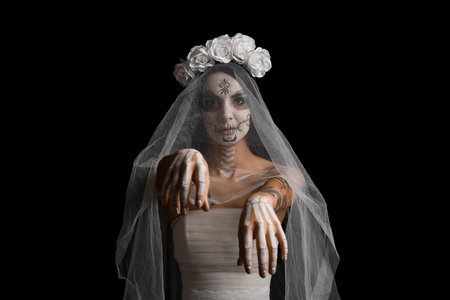 Beautiful young woman dressed as dead bride for Halloween party on black background