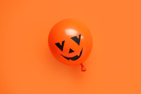 Funny Halloween orange balloon on color backgroundの写真素材