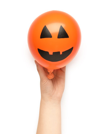 Female hand with funny Halloween balloon on white backgroundの写真素材