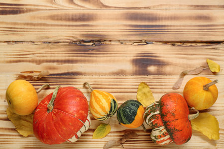 Autumn composition with pumpkins and leaves on wooden background
