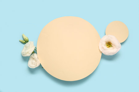 Composition with blank paper sheets and beautiful eustoma flowers on blue background