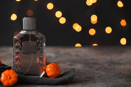 Bottle of elegant perfume with pumpkins for Halloween celebration on grunge table against blurred...