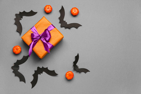 Paper bats with pumpkins for Halloween party and gift box on gray backgroundの写真素材