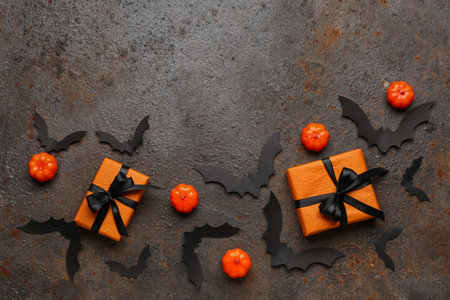 Paper bats with pumpkins for Halloween party and gift boxes on dark backgroundの写真素材
