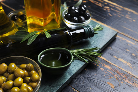 Bowls with olives and oil on black wooden backgroundの写真素材