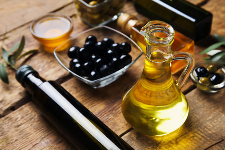 Jug and bottle of fresh olive oil on wooden backgroundの写真素材