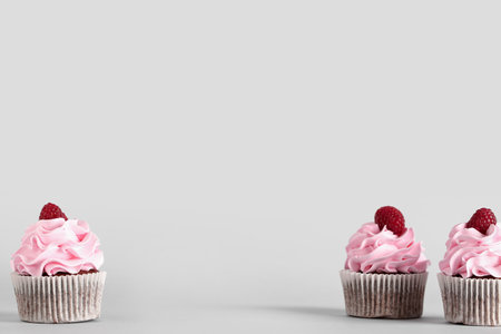 Tasty raspberry cupcakes on gray backgroundの写真素材