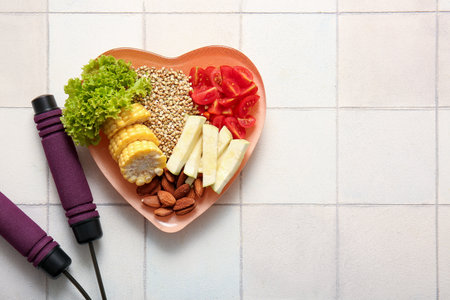Plate with fresh healthy products and jumping rope on light tile background. Diet conceptの写真素材