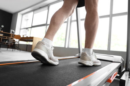 Sporty mature man training on treadmill at home, closeupの写真素材