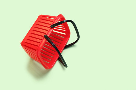 Small red shopping basket on green background