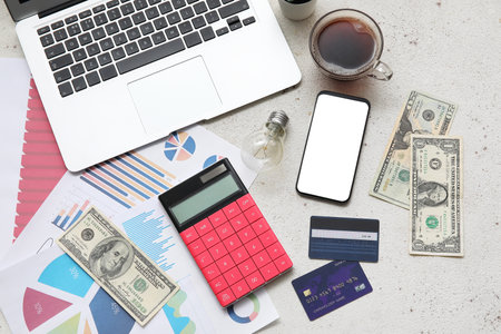 Laptop, calculator, smartphone, money and credit cards on gray grunge background. House rent conceptの写真素材
