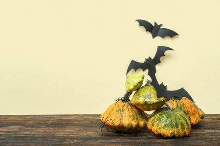 Squashes and paper bats for Halloween celebration on wooden tableの写真素材