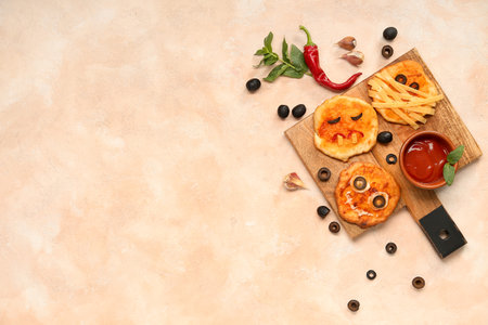 Board with different tasty Halloween mini pizzas and sauce on pink backgroundの写真素材