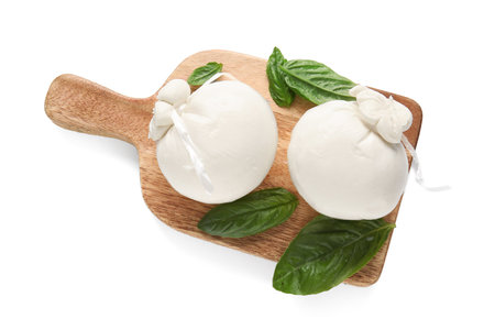 Wooden board of tasty Burrata cheese with basil on white backgroundの写真素材