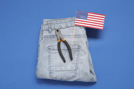Jeans with pliers and USA flag on blue background. Labor Day celebrationの写真素材