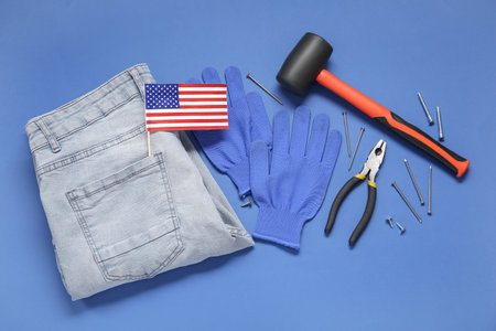 Different tools, USA flag, jeans and gloves on blue background. Labor Day celebrationの写真素材
