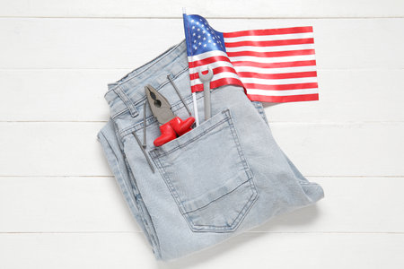 Jeans with tools and USA flag on white wooden background. Labor Day celebrationの写真素材