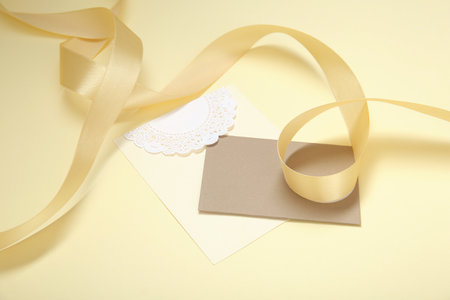 Blank card and golden ribbon on color backgroundの写真素材