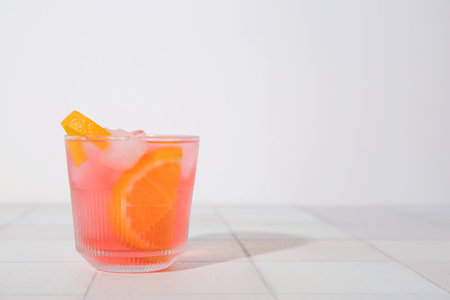 Glass of tasty Negroni cocktail on light tile tableの写真素材