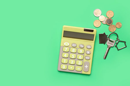 Calculator, keys and coins on green backgroundの写真素材