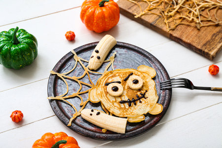 Composition with tasty Halloween breakfast and decorations on light wooden backgroundの写真素材