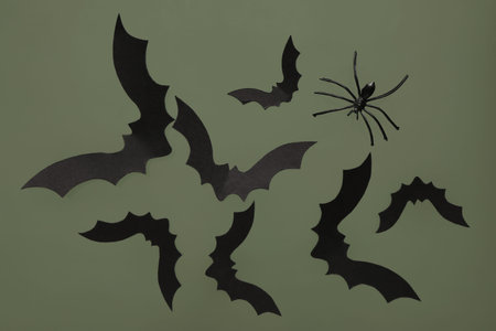 Paper bats and spider for Halloween party on green background