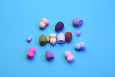 Different makeup sponges on blue background