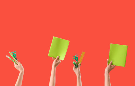 Hands with set of stationery on red backgroundの写真素材