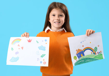 Cute little girl with drawings on blue backgroundの写真素材
