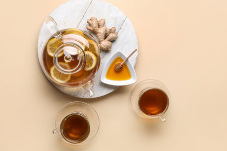 Composition with cups of tea, teapot and honey on beige backgroundの写真素材