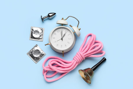 Alarm clock with sex toys, condoms and bell on blue backgroundの写真素材