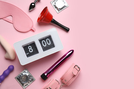 Alarm clock with sex toys, condoms and bell on pink backgroundの写真素材
