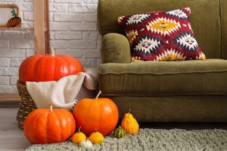 Basket with Halloween pumpkins near sofa in living roomの写真素材