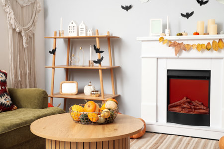 Basket with Halloween pumpkins on table in living roomの写真素材