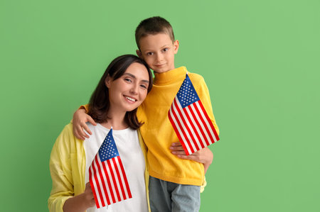 Little boy and his mother with USA flags on green background. Veterans Day celebrationの写真素材