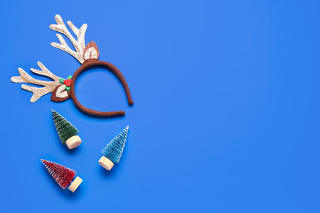 Cute Christmas reindeer horns with decor on blue backgroundの写真素材