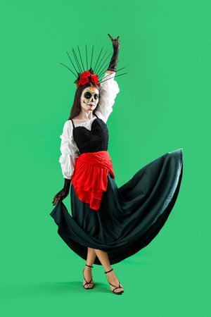 Beautiful woman dressed for Halloween on green backgroundの写真素材