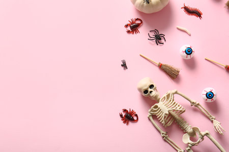 Halloween composition with candy bugs, skeleton and brooms on pink backgroundの写真素材