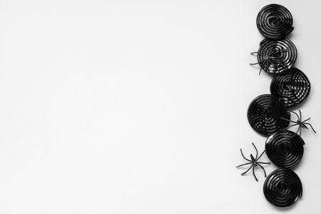 Halloween composition with licorice candies and spiders on gray backgroundの写真素材